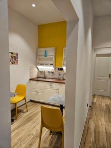 una cucina con pareti gialle, tavolo e sedie di Resort del Roster a Firenze