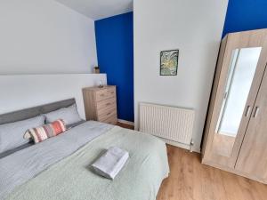 a bedroom with a bed and a blue wall at Stylish Retreat In Liverpool's Heart in Liverpool