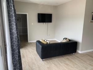 a black couch in a living room with a tv at Paradise Inn in Wildwood