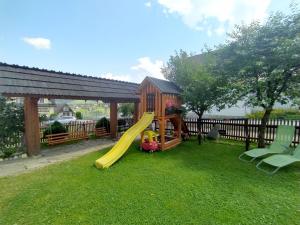 a playground with a slide in a yard at POKOJE GOŚCINNE U ZOŚKI in Murzasichle