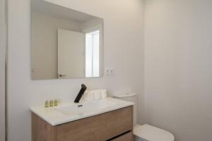 La salle de bains est pourvue d'un lavabo, d'un miroir et de toilettes. dans l'établissement Apartoyou - Enamorados, à El Puerto de Santa María