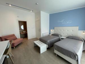 pokój hotelowy z 2 łóżkami i kanapą w obiekcie Villa Nascente w mieście Bitetto