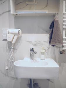 a bathroom with a white sink and a hair dryer at WentHotel A209 in Warsaw