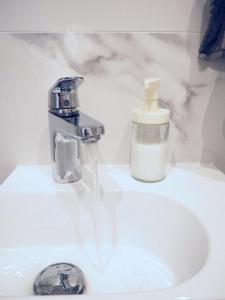 a bathroom sink with a faucet and a bottle of soap at WentHotel A209 in Warsaw