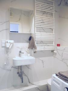 a white bathroom with a sink and a mirror at WentHotel A209 in Warsaw