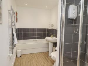 a bathroom with a sink and a toilet and a bath tub at Turning Tide in Chathill +14 photos