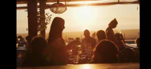 grupa ludzi siedzących przy barze o zachodzie słońca w obiekcie La Junior Suite w mieście Soorts-Hossegor