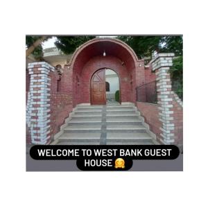 a brick building with a door with a sign that reads welcome to westbank bank at West Bank Guest House in Luxor