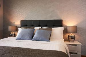 a bedroom with a large bed with two lamps at Victoria Mills Apartment Shipley in Shipley