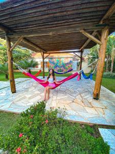 a woman sitting on a hammock under a pavilion at LS Villas Hotel & Spa in Águas de São Pedro