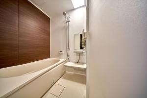 un bagno con vasca, WC e lavandino di おやど紀伊国屋 丸山町 庭 a Nagasaki Altre 16 foto