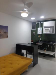 a room with a bed and a desk and a microwave at Lev Apartments - Apto Beira-Mar - Posto 2 - Copacabana in Rio de Janeiro