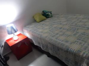 1 dormitorio con 1 cama y 1 lámpara en una mesa en Lev Apartments - Apto Beira-Mar - Posto 2 - Copacabana, en Río de Janeiro