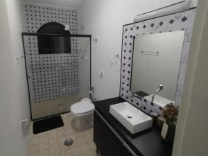 bagno con lavandino, servizi igienici e specchio di Apartamento Beira Mar - Enseada - Guarujá - 150 metros da praia a Guarujá