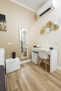 a bedroom with a desk and a mirror at Sant'Erasmo Rooms in Rome