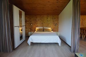 sypialnia z łóżkiem i drewnianym sufitem w obiekcie Le pavillon de l'étang w mieście Vagney