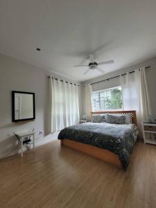 una camera con letto e ventilatore a soffitto di Downstairs @38 a Port Elizabeth
