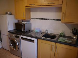 a kitchen with a sink and a washing machine at Laghead Steading Cottage in Gatehouse of Fleet