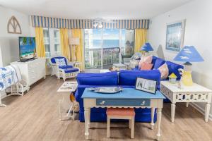 帕瓦雷斯岛Oceanfront Paradise: 3 Bdrm Condo, Pawleys Island的客厅里有一张蓝色的沙发和一张桌子