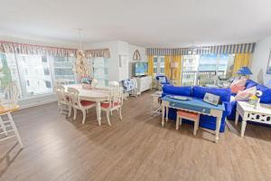帕瓦雷斯岛Oceanfront Paradise: 3 Bdrm Condo, Pawleys Island的客厅里有一张蓝色的沙发和一张桌子