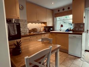 - une cuisine avec une table en bois et un comptoir dans l'établissement Pass the Keys Scallop Cottage Oasis of Calm, à Rye