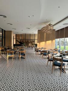 un ristorante con tavoli, sedie e pianoforte di The Arena Cam Ranh Resort all Luxury Service a Miếu Ông