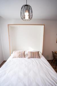 a bedroom with a white bed with two pillows at Apartman Krželj B1 in Livno