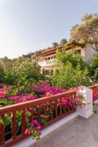 a balcony with pink flowers in front of a building at Studios Limnionas in Marathokampos