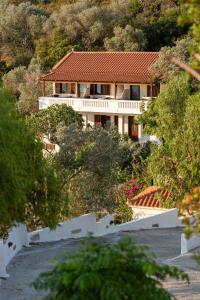 a house on a hill with trees in front of it at Studios Limnionas in Marathokampos