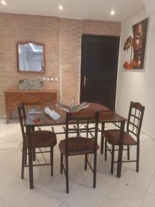 uma cozinha com uma mesa e cadeiras e um lavatório em APPARTEMENT Hana Majorelle em Marrakech
