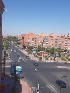 una calle de la ciudad con coches y motocicletas en la carretera en APPARTEMENT Hana Majorelle en Marrakech