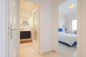 een witte slaapkamer met een bed en een badkamer bij Luxury flat on the Cote d'Azur in Villeneuve-Loubet
