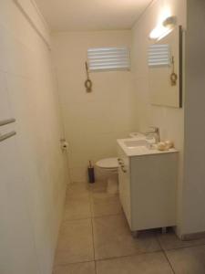 ein weißes Bad mit einem WC und einem Waschbecken in der Unterkunft MADRAS LODGE in Le Diamant