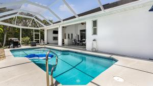a swimming pool in a house with a glass roof at Private Pool, Spacious Kitchen, Backed Up To Canal in Cape Coral