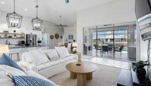 a living room with a white couch and a table at Private Pool, Spacious Kitchen, Backed Up To Canal in Cape Coral