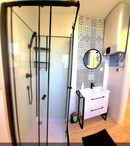 a shower with a glass door in a bathroom at Leśny Zakątek in Jarosławiec