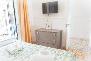 ein Schlafzimmer mit einem Bett und einem TV an der Wand in der Unterkunft Casa Rosalba in Noto