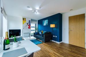 a living room with a couch and a blue wall at Modern Central Manchester Serviced Apartment with 24-7 Gym Access in Manchester