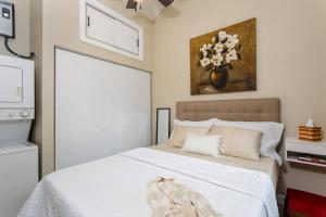 a bedroom with a white bed with a painting on the wall at Downtown Tiny Life - Experience Tiny Living! in Orlando
