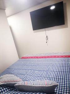 Hospedaje 51b في بوغوتا: غرفة نوم بسرير من اللون الأزرق والأبيض وتفقد الشراشف