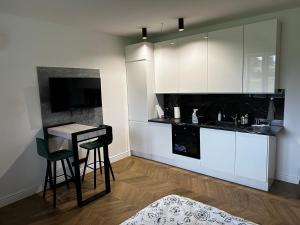 a kitchen with white cabinets and a table and chairs at Habibi in Solec