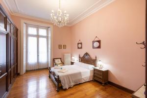 a bedroom with a bed and a chandelier at Jauregi - baskeyrentals in Lekeitio