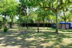 a park with trees and a tent in the background at Camping Klaus in Cavallino-Treporti