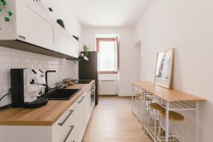 Una cocina con gabinetes blancos y una encimera de madera. en Ballaro' House, en Palermo 28 fotos más