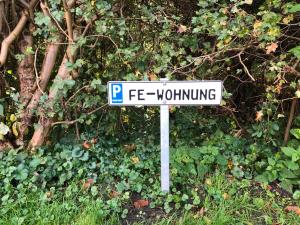 a white street sign sitting in the grass at Moderne großzügige Souterrainwohnung Zarrentin Gallin Schaalsee Natur Wald Wasser in Gallin