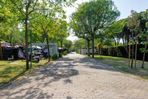 a brick road in a park with trees and tents at Camping Klaus in Cavallino-Treporti