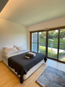 a bedroom with a bed and a large window at Cascais Lux Apartment 521 letter in Cascais