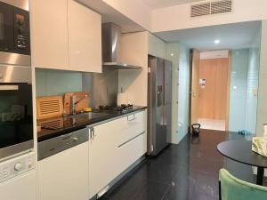 uma cozinha com armários brancos e um piso preto em Cascais Lux Apartment 521 letter em Cascais