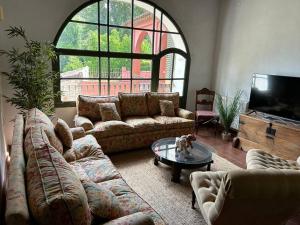 un soggiorno con divani, tavolo e TV di Casa Rural en Galaroza a Galaroza