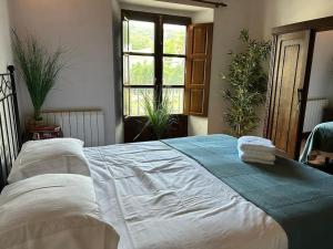 - une chambre avec un grand lit et des serviettes dans l'établissement Casa Rural en Galaroza, à Galaroza